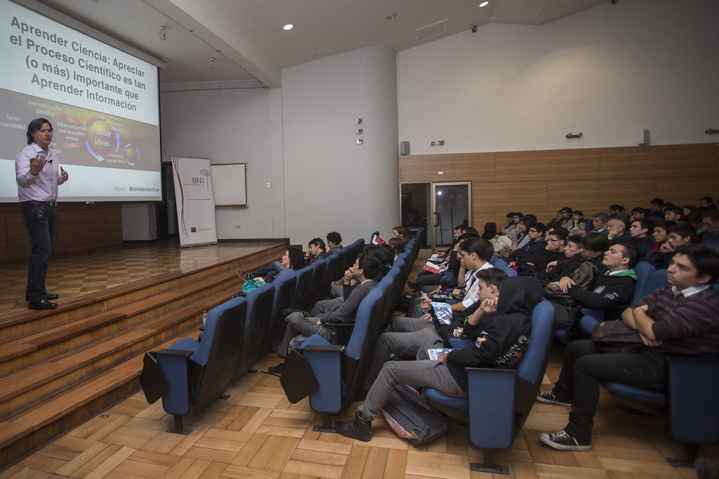 Estudiantes de enseñanza media en un auditorio siguiendo una charla sobre el proceso científico