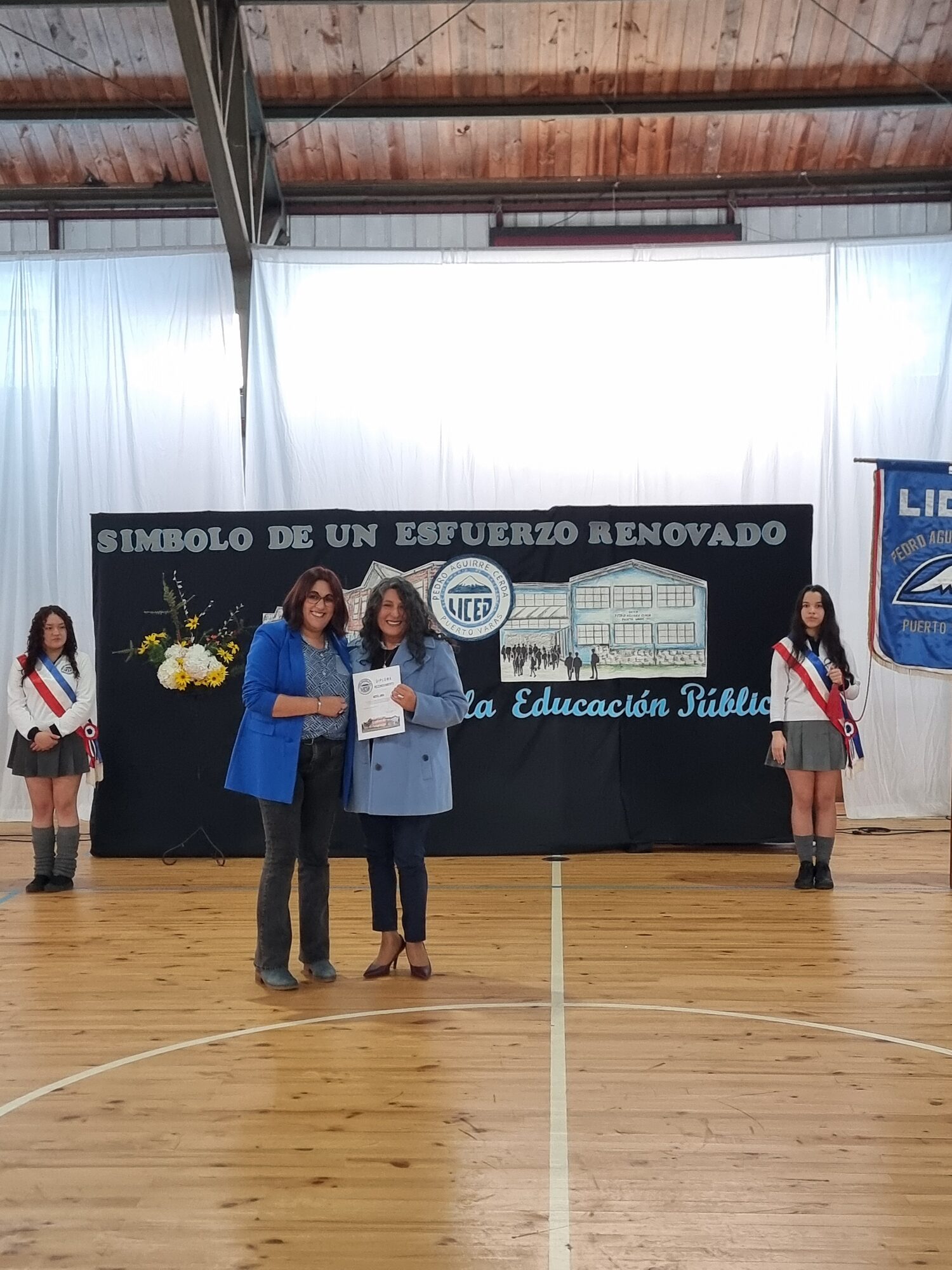Premiación frente al banner de los 69 años de excelencia del liceo