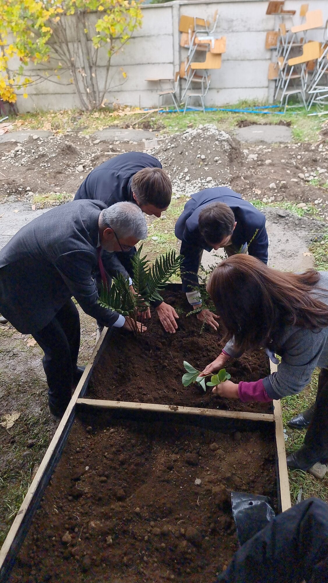 Estudiantes plantando en el huerto durante las actividades de aniversario