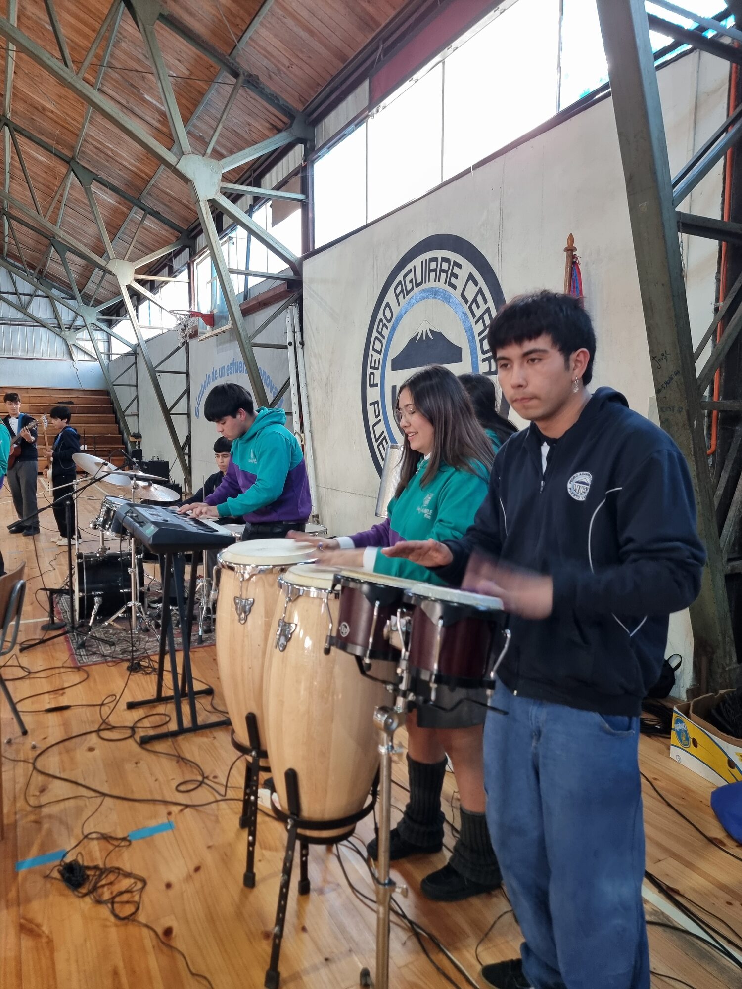 Estudiante tocando guitarra durante el acto de bienvenida a 1° medios