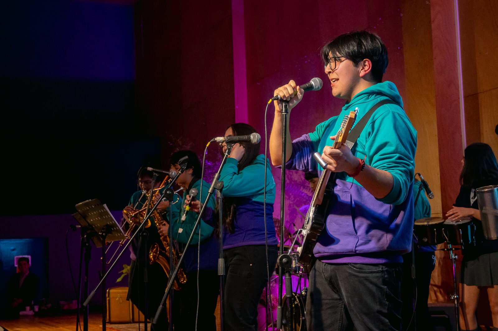 Estudiante del taller de música cantando frente al público en el Festival de la Lluvia