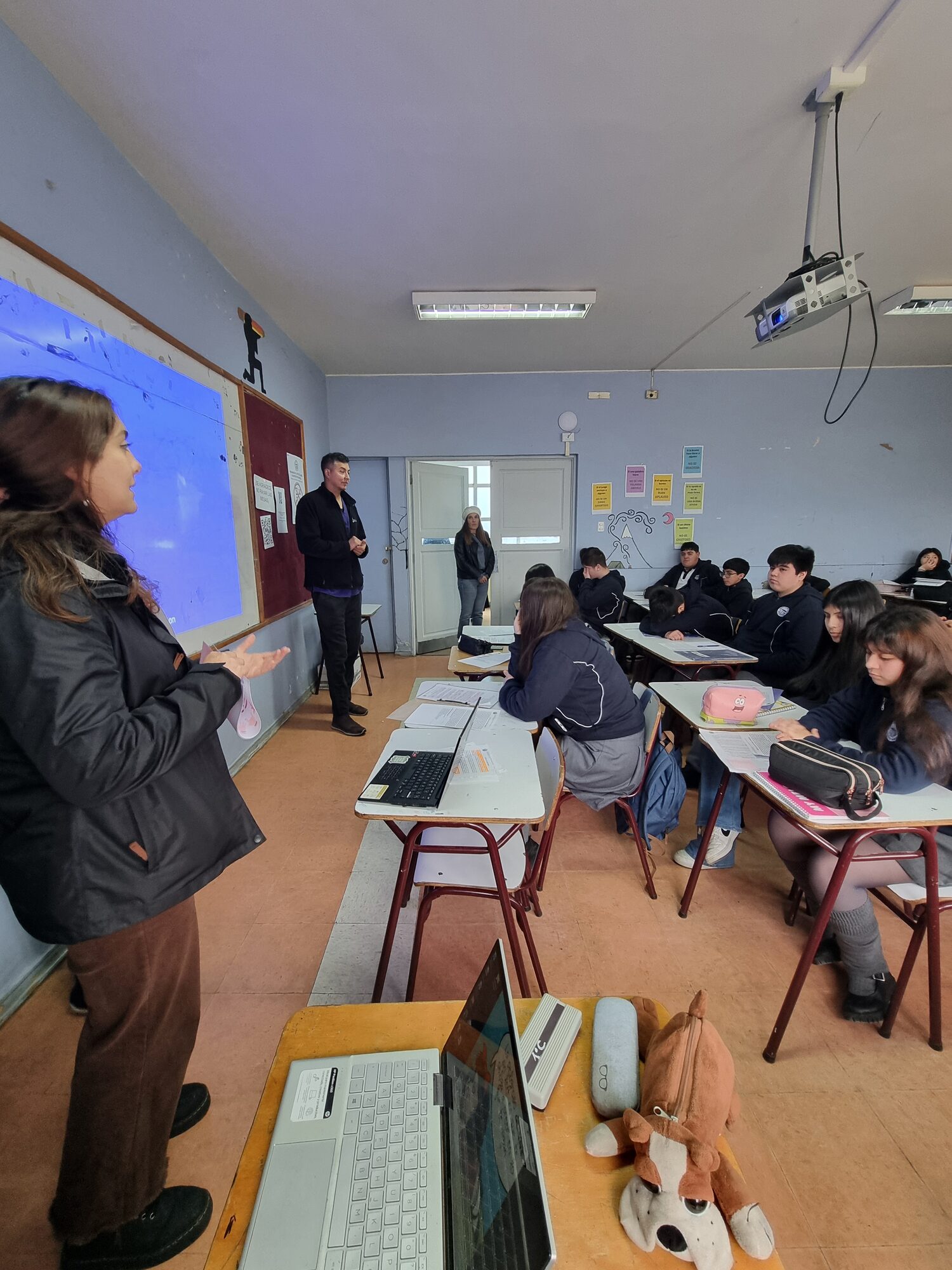 Profesional de salud conversando con estudiantes durante la charla de CESFAM