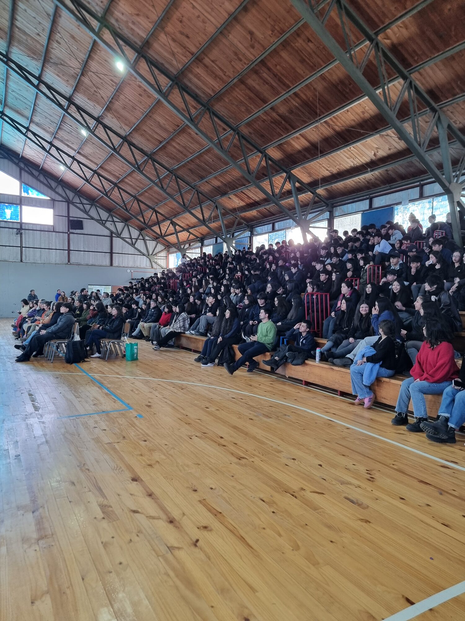 Estudiantes reunidos en el gimnasio durante la actividad SNCAE