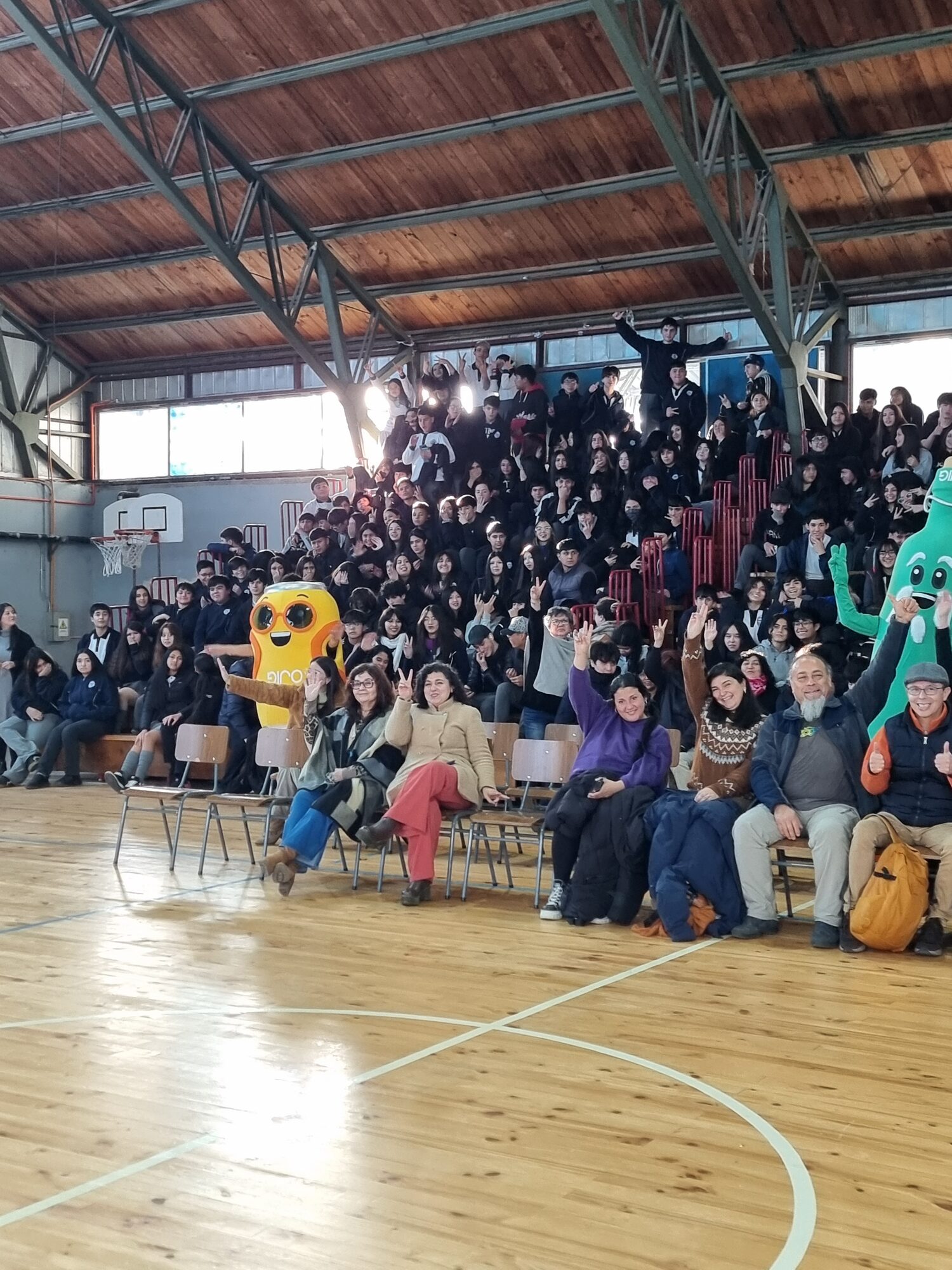 Mascota junto a estudiantes en el gimnasio durante la actividad SNCAE