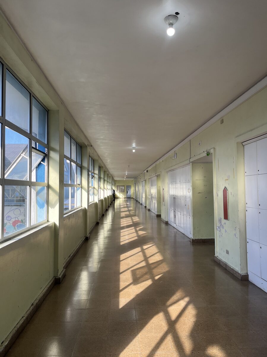 Pasillo del liceo con casilleros y ventanales